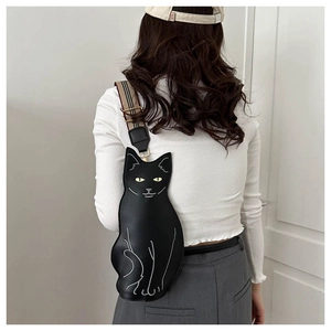 Detail showing the cartoon black cat crossbody bag with adjustable striped strap on model