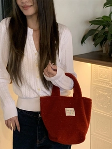 Plush burgundy tote bag with logo patch styled with a knit cardigan and jeans
