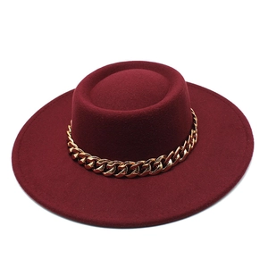 Detail view of burgundy flat top wool felt boater hat with a chunky gold chain accessory
