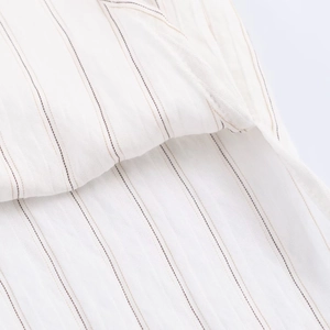 Detailed macro view of high-quality white cotton fabric with fine brown vertical stripes
