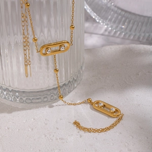 Collier en acier doré avec deux pendentifs géométriques sertis de zircons mobiles brillants