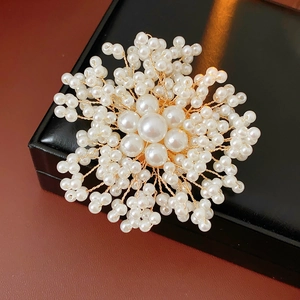 Close-up of handmade flower pearl brooch with gold wire on black leather jewelry box