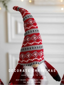 Gros plan d'un gnome de Noël avec chapeau en tricot rouge-gris et longue barbe blanche