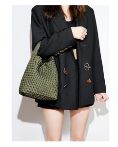 Detailed close-up of dark green woven tote bag with intricate texture on a model
