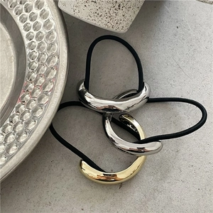 Close-up of minimalist gold and silver metal half-round ponytail cuffs on elastic bands