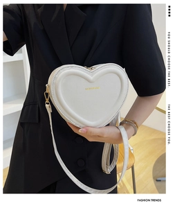 Détail du sac coeur en cuir PU blanc avec surpiqûres élégantes et fermeture éclair dorée