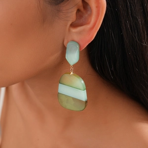 Close-up of bohemian acetate geometric earrings in mint and olive green tones