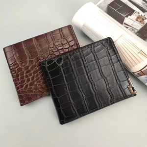 Detail of men's wallets in black and dark brown with crocodile pattern embossed texture