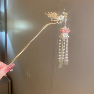 Détail d'une épingle à cheveux phénix dorée avec lotus rose et pompons de perles