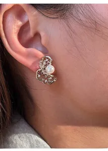 Detailed view of butterfly stud earrings with hollow metal craft, zircon and white pearl