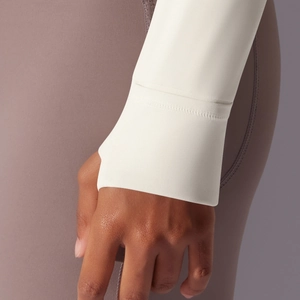 Close-up of white sports jacket cuff with thumbhole detail for yoga and running