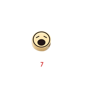 Macro shot of gold-plated stainless steel round bead with yawning emoji for DIY jewelry