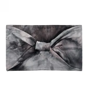 Detail of wide tie-dye sport headband with cross-knot design and elastic knit fabric