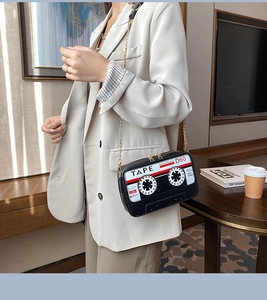 Detail of vintage cassette tape crossbody bag with gold chain and printed retro graphics