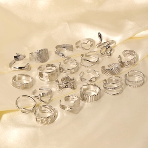 Set of 18 silver stainless steel rings with heart, snake, and chain patterns on silk cloth