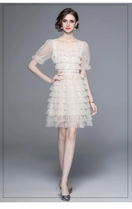 Vue de face d'une robe en dentelle abricot à col carré et manches bouffantes