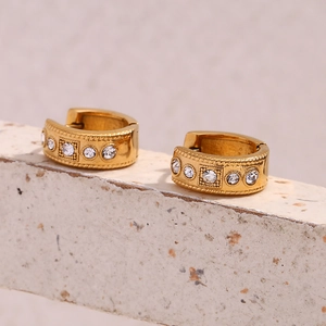 Macro detail of 18K gold plated twisted hoop earrings with sparkling crystal stones