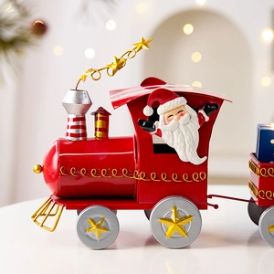 Red iron Christmas train ornament with Santa figure and gold star details on a warm background