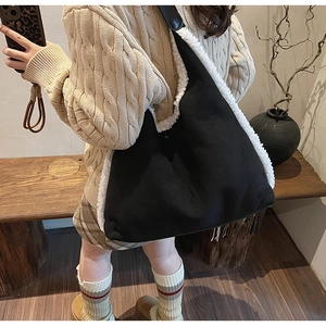 Detail of black faux fur shoulder bag worn by model against vintage wood background