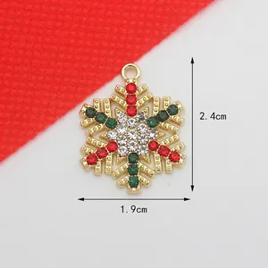Detailed view of a 2.4cm gold snowflake pendant set with red and green rhinestones