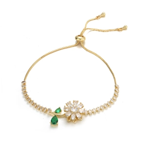 Detail of adjustable gold sunflower bracelet with white cubic zirconia and green leaves
