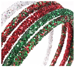 Close-up of glitter hairbands in red, green, and silver colors with sparkly textures