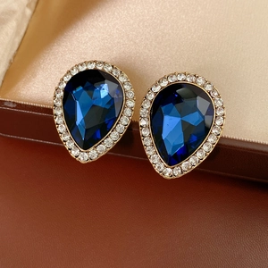 Gros plan de boucles d'oreilles vintage en forme de goutte bleue et diamants sertis