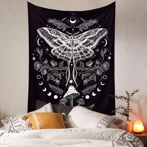 Detail of bohemian moon phase tapestry with moth and mushroom motifs on a bedroom wall