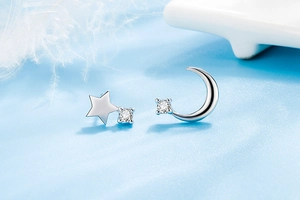 Macro view of asymmetric silver star and moon earrings with sparkling zircon accents