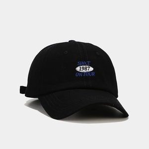 Dettaglio del cappello da baseball nero con ricamo blu SINCE ON TOUR e numeri 1987