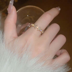 Detailed view of gold-plated zircon pavé ring with parallel cross design on index finger