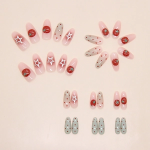 Detailed close-up of gradient press-on nails with 3D tomato motifs and star patterns