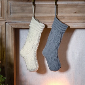 Knitted Christmas stockings in cream and grey colors with cable-knit pattern and hooks
