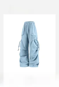 Dettaglio dei pantaloni cargo azzurri a vita alta con coulisse e ampie tasche laterali