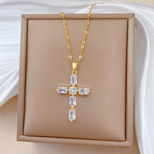 Gros plan détaillé du pendentif croix en titane doré serti de cristaux scintillants