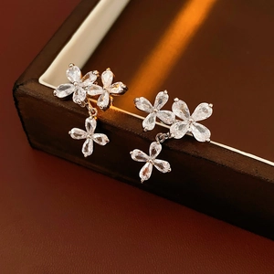 Macro shot of silver zircon flower earrings on a luxury brown leather jewelry box