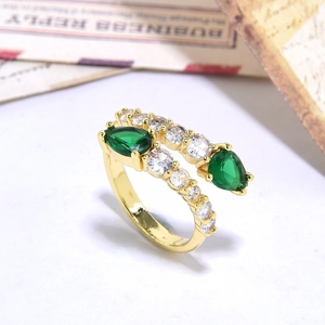 Detailed macro view of gold-tone cross ring with green pear-shaped zirconia stones