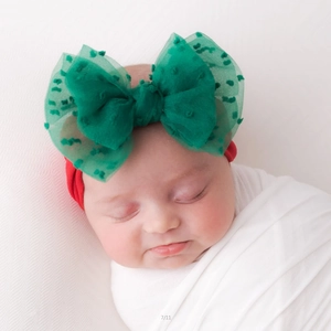 Detail of red elastic baby headband with large green mesh bow and 3D dots for Christmas