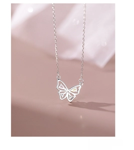Macro shot of S925 sterling silver butterfly pendant with colorful gemstones and soft pink tone