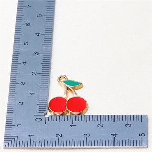Detail view of cherry fruit charm with dimensions 2.2cm x 2.1cm on measurement scale