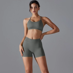 Detail of high-waist ribbed yoga shorts and strappy sports bra in dark grey green
