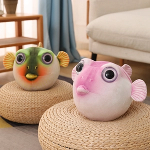 Détail de poupées poissons-globes en peluche rose et vert sur tabourets tressés
