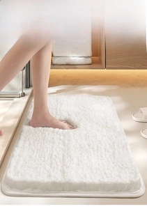 Close-up of thick white shaggy bathroom mat showing plush texture and non-slip backing