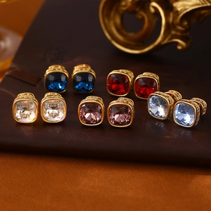 Vue macro de boucles d'oreilles carrées en cristal cinq couleurs avec monture dorée