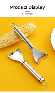 Detail of two stainless steel corn peelers with hanging loops on a yellow background