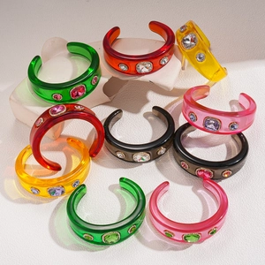 Retro geometric resin bangles with colorful rhinestones on a white geometric stage