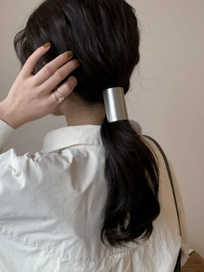 Minimalist silver matte metal hair cuff and sleek twisted ring shown on a model