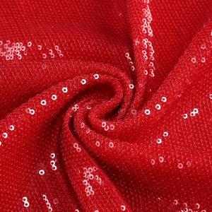 Close-up of sparkling red sequins fabric with metallic reflections on mesh backing