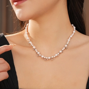 Detail view of pearl necklace with silver-claw cubic zirconia and graduated beads on neck