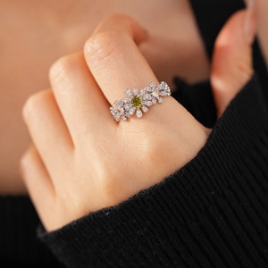 Detail of flower ring with yellow stone and white zircon petals on hand